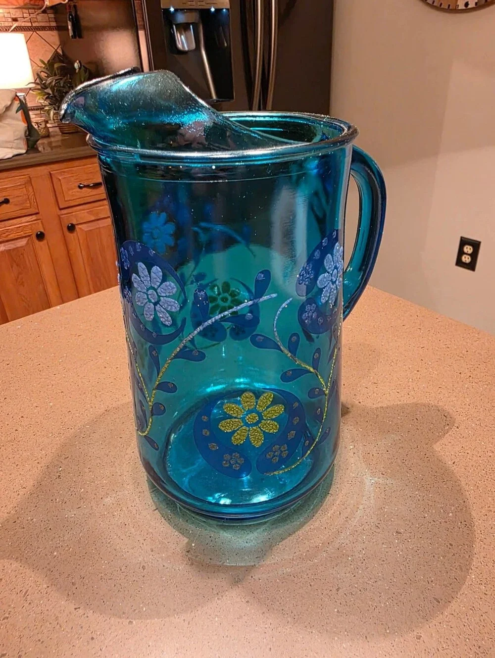 Vintage turquoise Libbey glass pitcher with painted design.